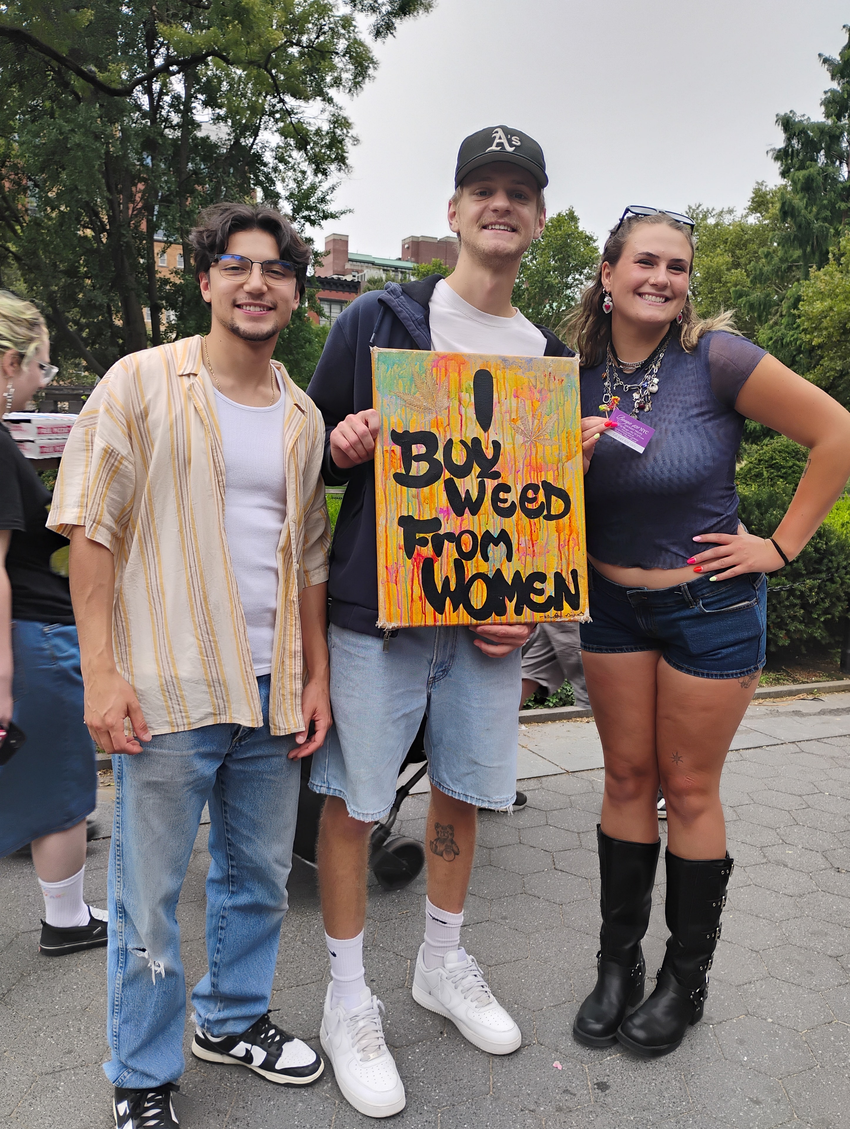 Group holding Buy Weed From Women sign at Bougie 420 event
