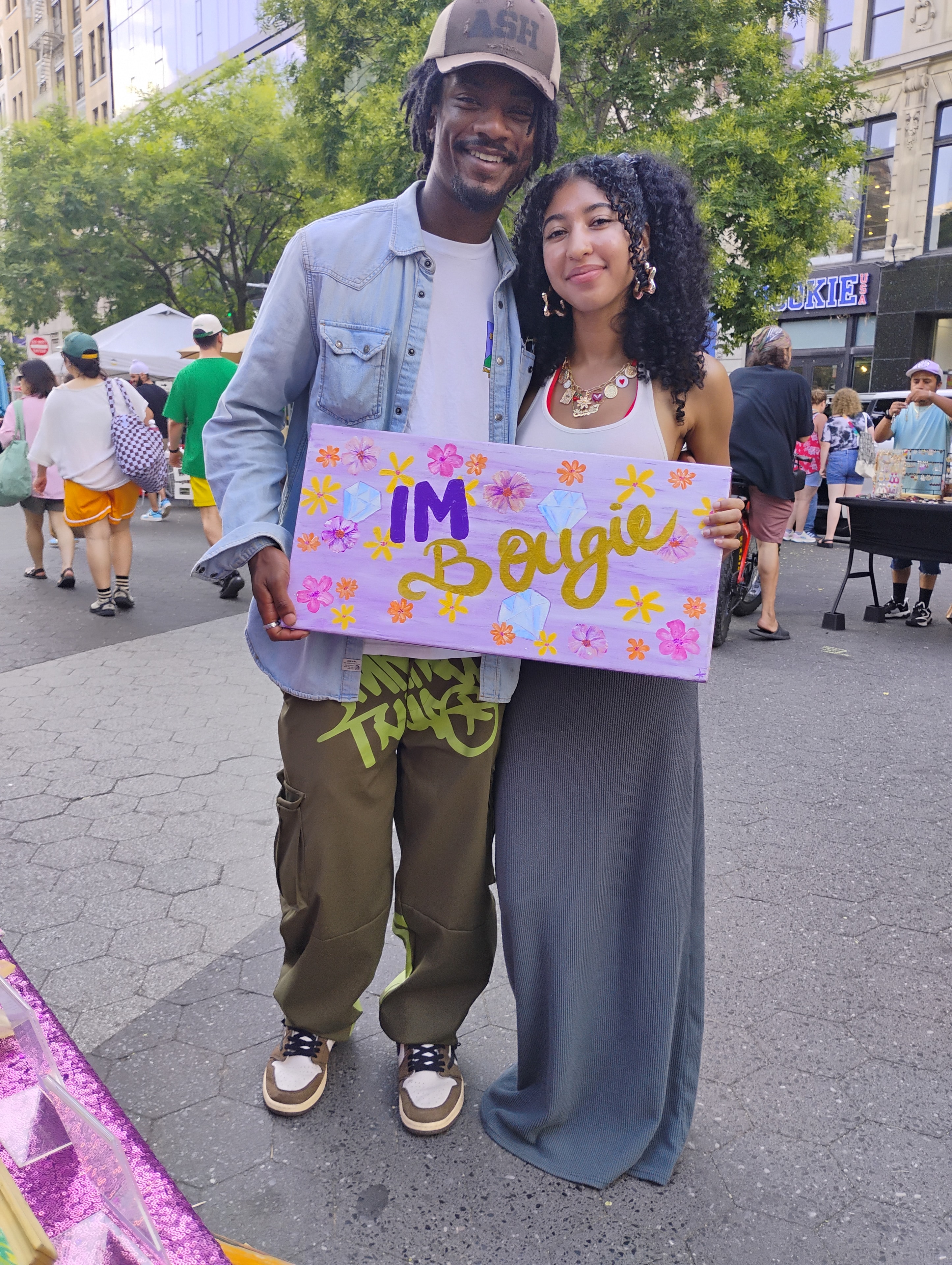 Couple holding Bougie 420 sign at NYC event